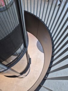 Ocelový límec průchodu střešní konstrukcí pro výtahovou šachtu válcového tvaru.